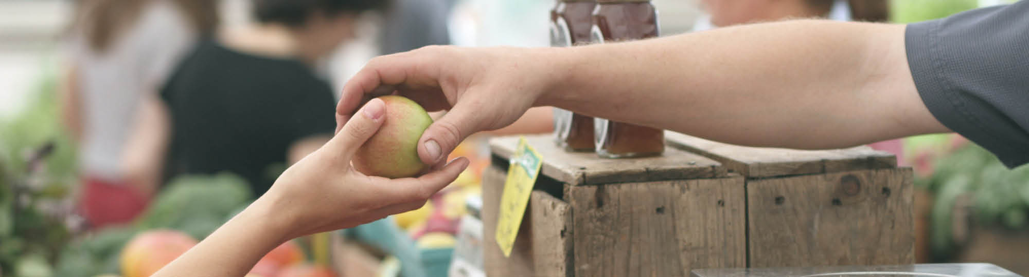 An adult handing an apple to a child
